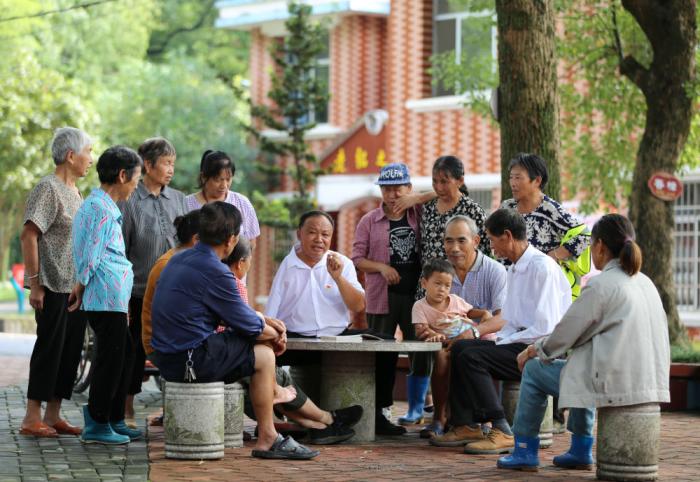 　江西芦溪县宣风镇珠亭村人民调解员阳昌绍(中)为珠亭村的百姓宣讲民法典知识(2021年8月17日摄)。新华社记者 胡晨欢 摄